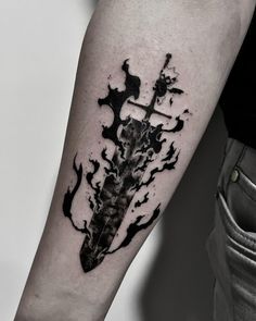 a black and white photo of a cross with flames on the arm, done by an artist