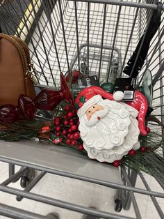 a shopping cart filled with christmas items and a santa clause ornament sitting on top of it