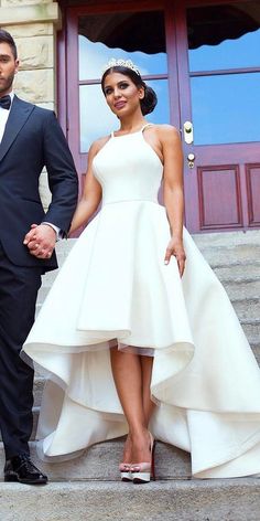 a man and woman in formal wear standing on steps next to each other holding hands