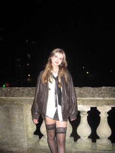 a woman in tights and stockings is standing on a ledge with her legs crossed