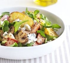 a white bowl filled with salad and potatoes