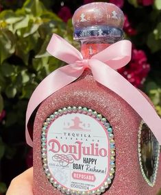 a pink bottle with a ribbon around it that says donjullo happy day zakaki