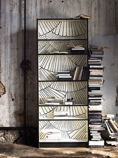 a book shelf with books on it in front of a concrete wall and metal frame