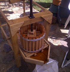 a large wooden barrel sitting on top of a stone floor next to a white bucket