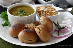 a white plate topped with rolls and soup