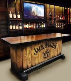 a wooden bar with bottles on the wall behind it and a television in the background