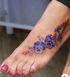 a woman's foot with purple flowers on the bottom and one flower in the middle