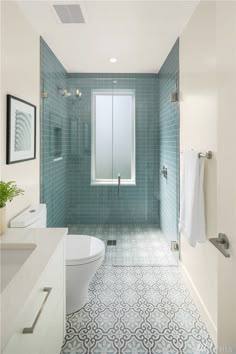 a bathroom with blue tile and white fixtures