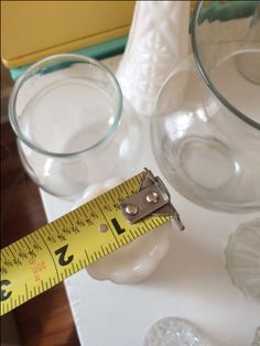 a measuring tape is on top of glass vases