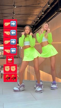 two girls in neon green outfits standing next to each other with their hands on their hips