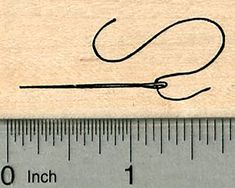 a wooden rubber stamp with a needle and thread