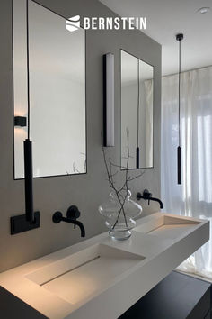 a bathroom with two sinks and mirrors on the wall