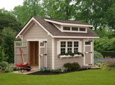 a garden shed with a wheelbarrow in the yard