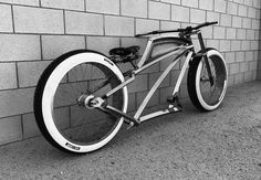 a bicycle parked against a brick wall on the side of a building in black and white