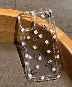 a phone case with pink flowers and butterflies on it sitting on top of a chair