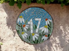 a mosaic on the side of a building with flowers