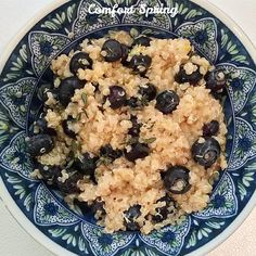 a bowl filled with rice and blueberries on top of a table