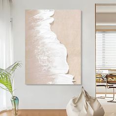 an abstract painting hangs on the wall above a chair and table in a modern living room