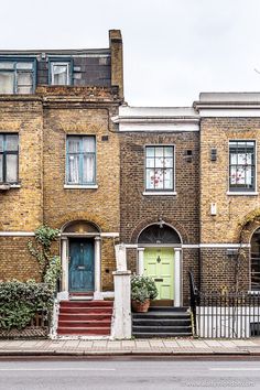 an old brick building with stairs leading to the front door