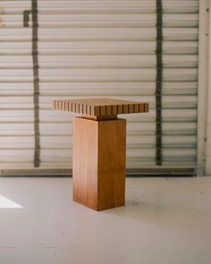 a wooden object sitting on top of a white floor next to a closed garage door