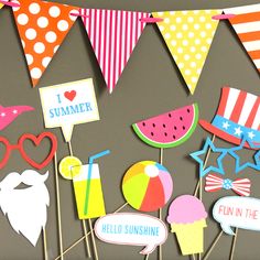 an assortment of party decorations on sticks with flags in the shape of watermelon and ice cream