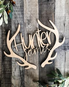 a wooden sign that says hunter games with antlers and leaves on the wood background