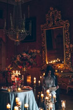 a woman sitting at a table surrounded by candles