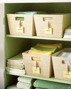 the shelves are filled with folded towels and other items in bins on top of them