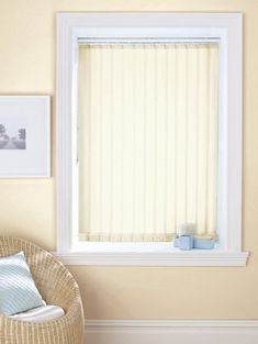 an empty chair in front of a window with vertical blinds on the windowsills