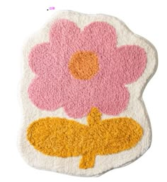 a pink and yellow flower rug on top of a white floor