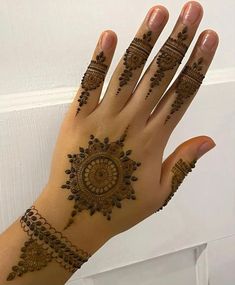 a woman's hand with henna tattoos on it