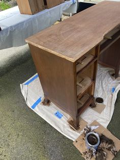 a wooden desk sitting on top of a pile of cardboard