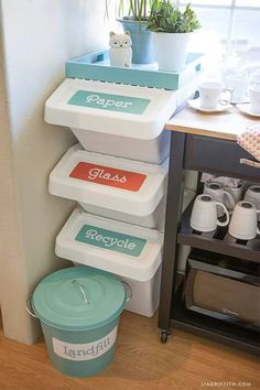 three plastic containers stacked on top of each other next to a potted plant in a window sill