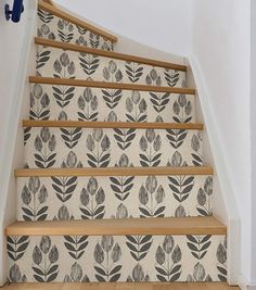 the stairs are decorated with black and white wallpaper, which has leaves on it