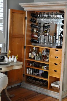 an old fashioned liquor cabinet is filled with bottles and glasses