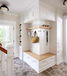 a kitchen with white cabinets and wooden shelves