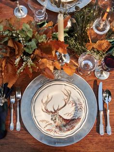 a plate with a deer head on it next to silverware