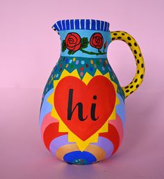 a colorful painted vase with the word hi on it's side and a heart