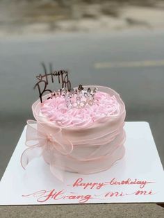 a pink birthday cake on top of a white card