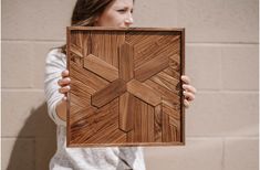 a woman holding up a wooden cross in front of her face