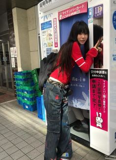 a woman standing in front of a vending machine with her hand on the door