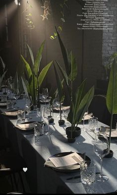 the table is set with place settings for two people to sit at, and there are plants in vases