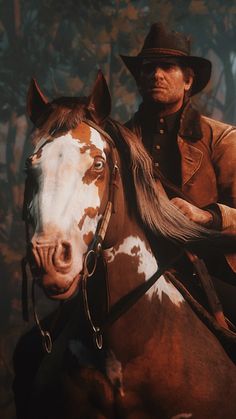 a man riding on the back of a brown and white horse next to a forest