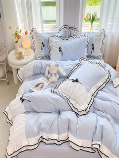 a bed with blue and white comforters in a bedroom next to a window,