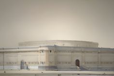 a large white building sitting on top of a snow covered field