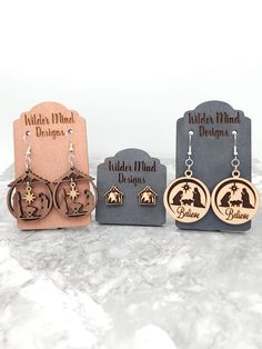 Beautiful Walnut and Maple Wood Nativity Earrings.  They are made of maple and walnut plywood, made to be stronger and more durable. These earrings are laser cut, laser engraved and are super lightweight making them easy to wear all day!  *Please Reference Size Guide Picture for sizing* Ear wires are made from surgical stainless steel. Since these earrings are handmade, I highly recommend taking them off for any water related activities such as swimming or showering and while sleeping. They come Laser Cut Earrings Wood Christmas, Wood Nativity Earrings, Nativity Earrings, Laser Cut Wood Projects, Laser Creations, Laser Earrings, Manger Nativity, Laser Christmas, Laser Engraved Earrings