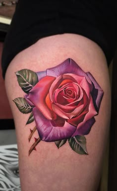 a pink rose tattoo on the thigh