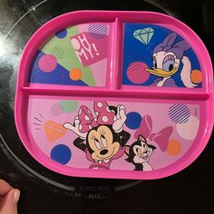 a child's tray with mickey mouse and minnie mouse pictures on the side, in front of a black background