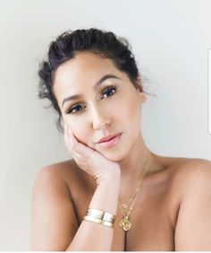 a beautiful young woman posing with her hand on her chin