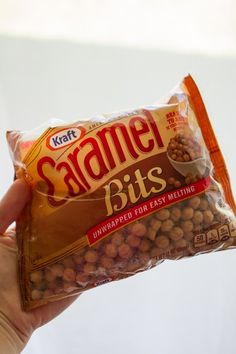 a hand holding a bag of caramel bits